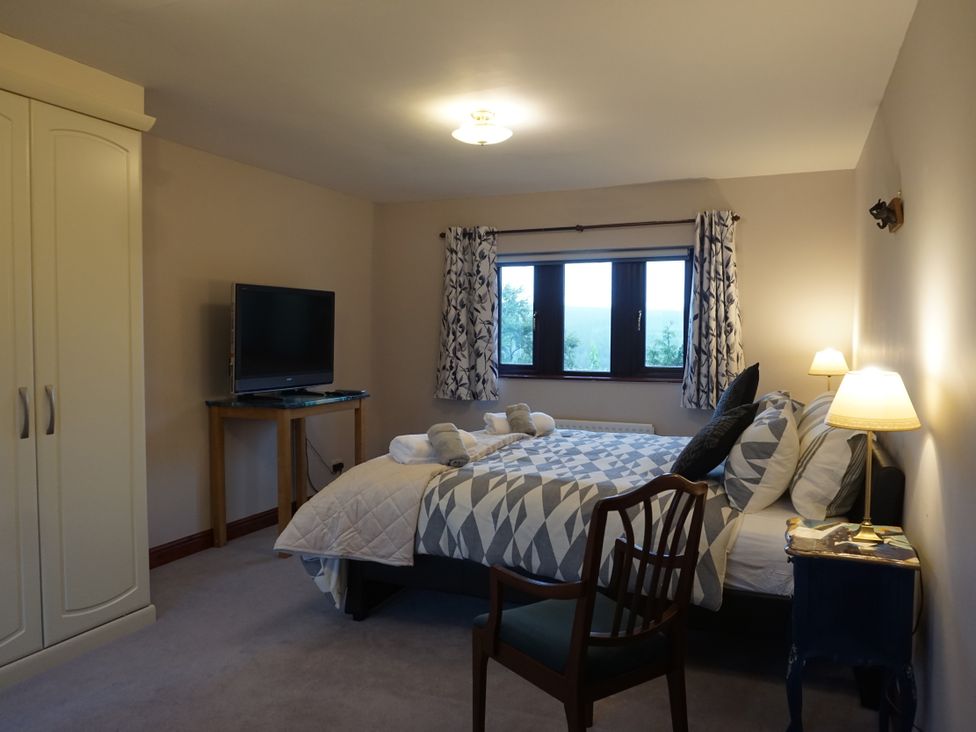 A bedroom with a bed and television at The Peak View Holmfirth
