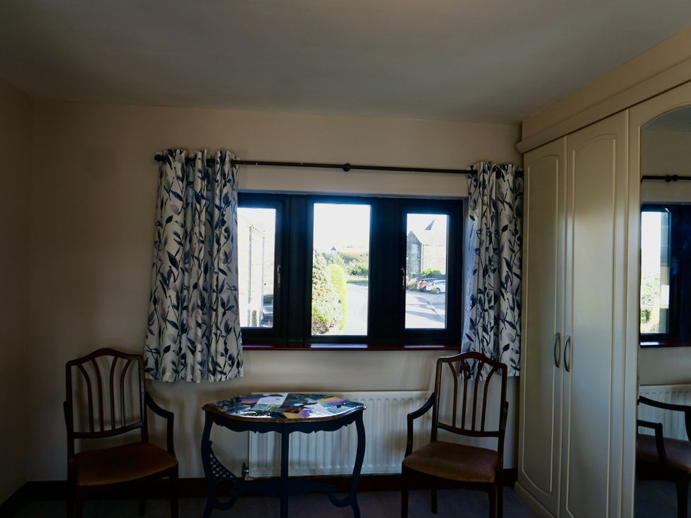 A snug with two chairs and a table by the window at The Peak View Holmfirth