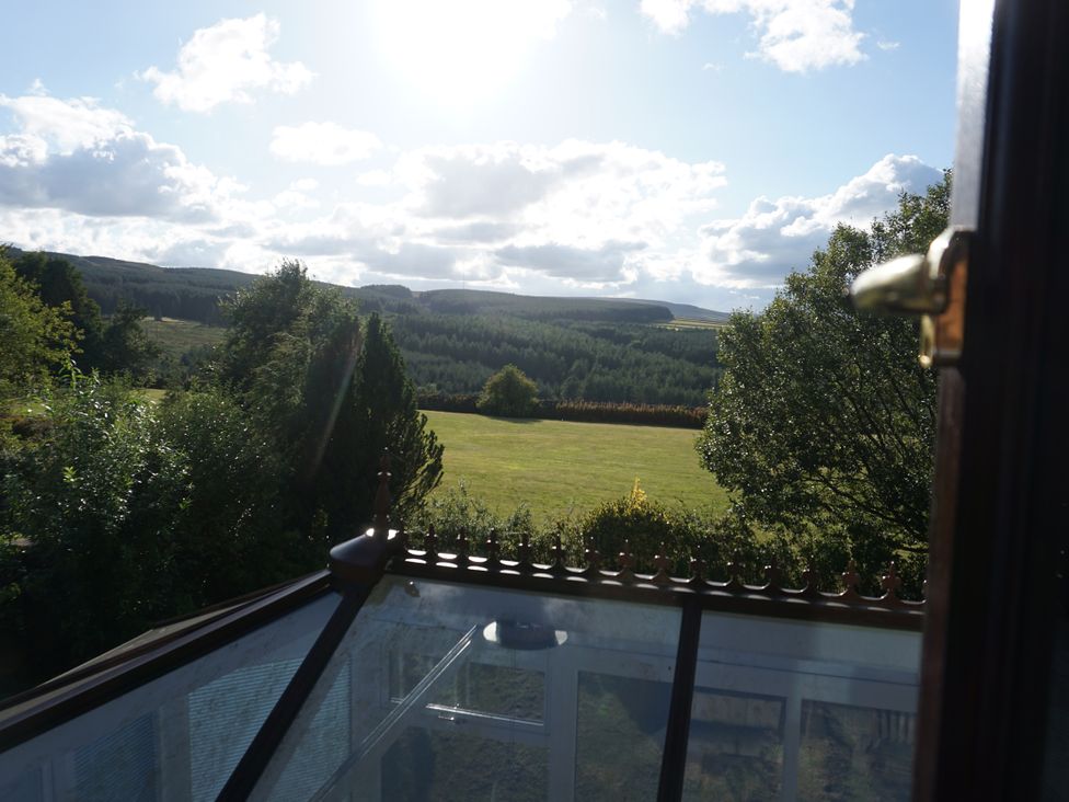 A view of a field and trees from a window at The Peak View Holmfirth