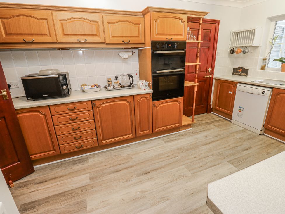 A kitchen with cabinets, microwave, kettle, oven, and sink at The Peak View Holmfirth