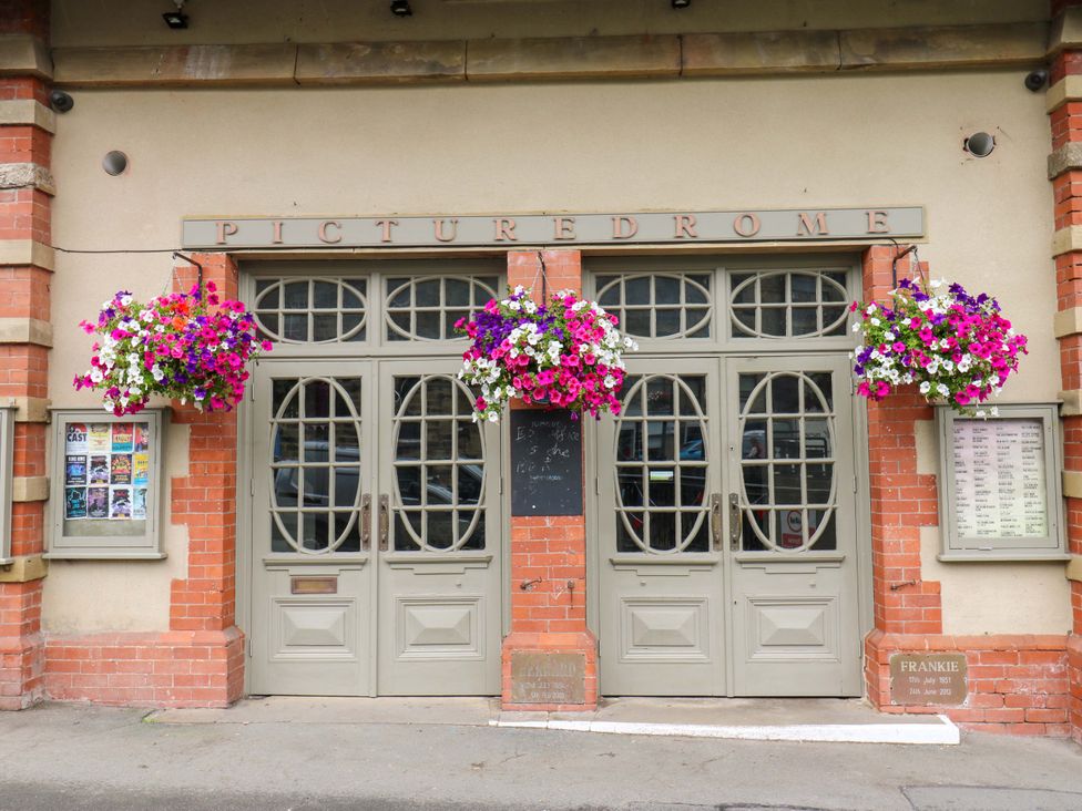 An entrance of a building with flowers and signage at The Peak View Holmfirth in Hade Edge, Yorkshire