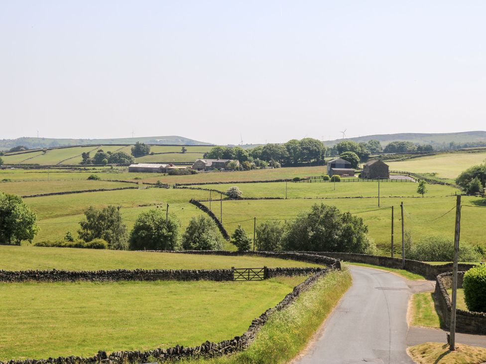 A rural landscape with fields and farm buildings at The Peak View Holmfirth, Hade Edge, Yorkshire