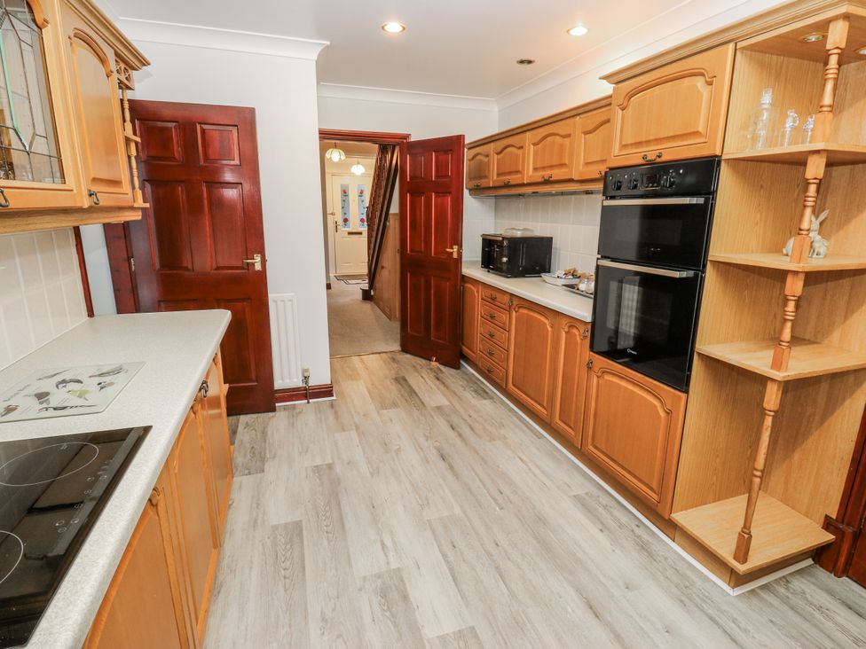 A kitchen with wooden cabinets and appliances at The Peak View Holmfirth Hade Edge, Yorkshire
