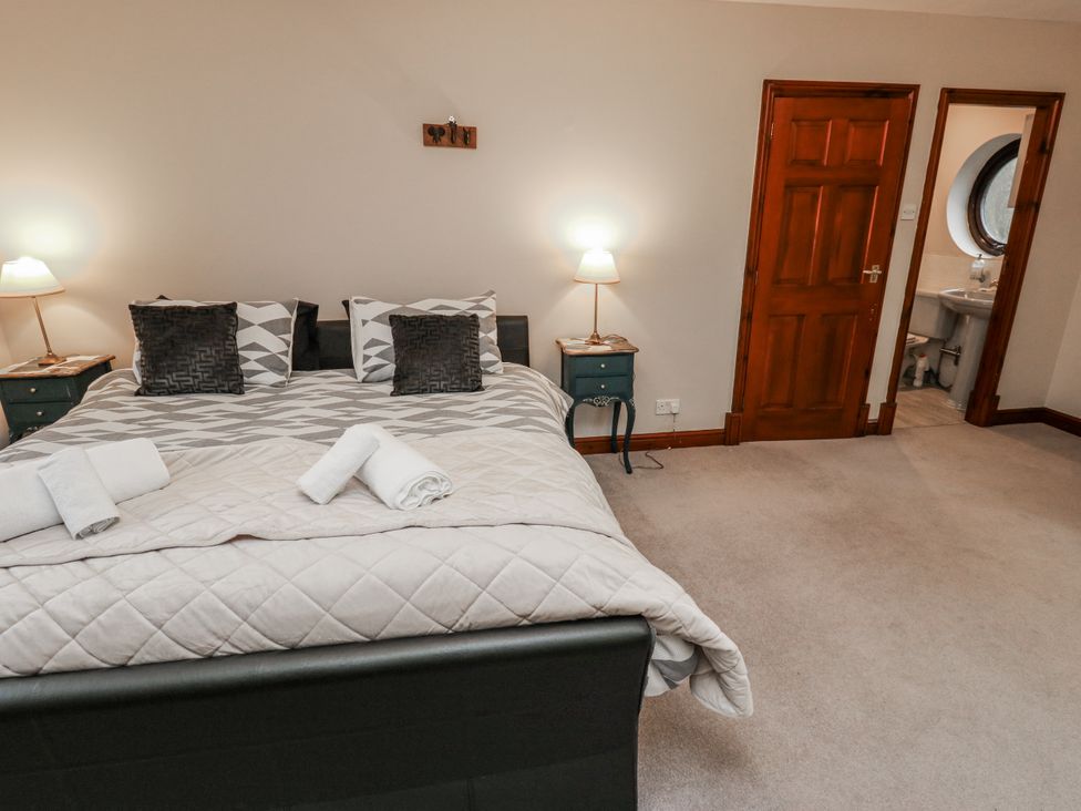 A bedroom with bed and bathroom door at The Peak View Holmfirth in Hade Edge, Yorkshire