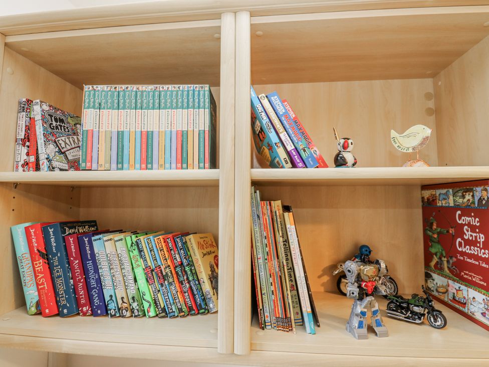 A bookshelf with various books and figurines at The Peak View Holmfirth in Hade Edge, Yorkshire