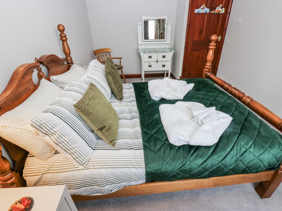 A bedroom with a wooden bed and a mirror at The Peak View Holmfirth Hade Edge, Yorkshire