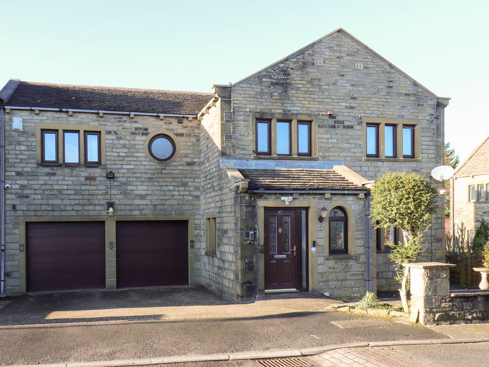 A house with a front entrance and garage doors at The Peak View Holmfirth in Hade Edge, Yorkshire
