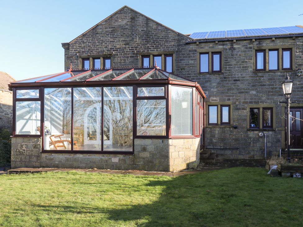 A conservatory attached to a stone house at The Peak View Holmfirth in Hade Edge, Yorkshire