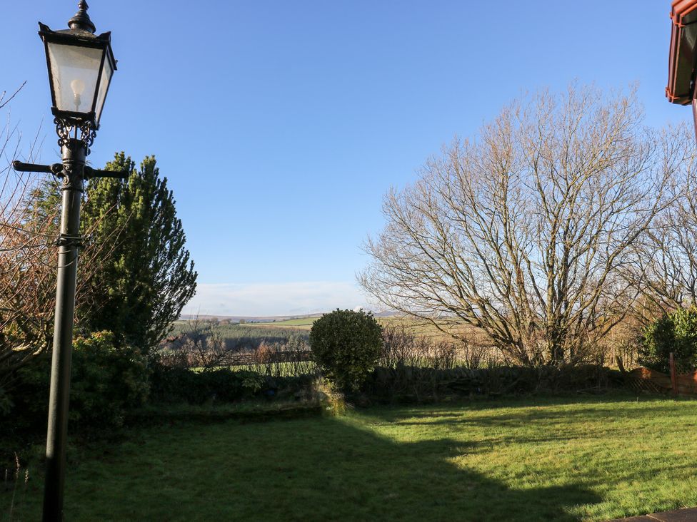 A garden with a lamp post and trees at The Peak View Holmfirth Hade Edge, Yorkshire