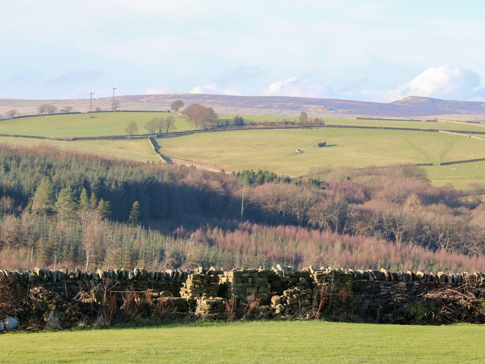 A panoramic view of fields and hills with a stone wall at The Peak View Holmfirth Hade Edge, Yorkshire