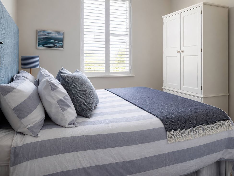 A bedroom with a bed and wardrobe at Wood Cottage 