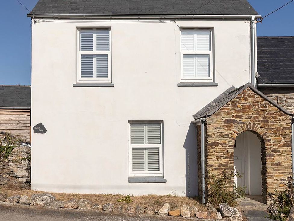 A facade of a house with windows and a stone archway at Wood Cottage