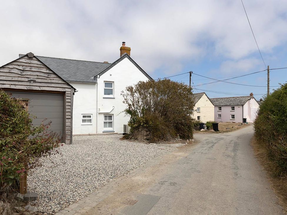 A house and garage on a gravel driveway at Wood Cottage