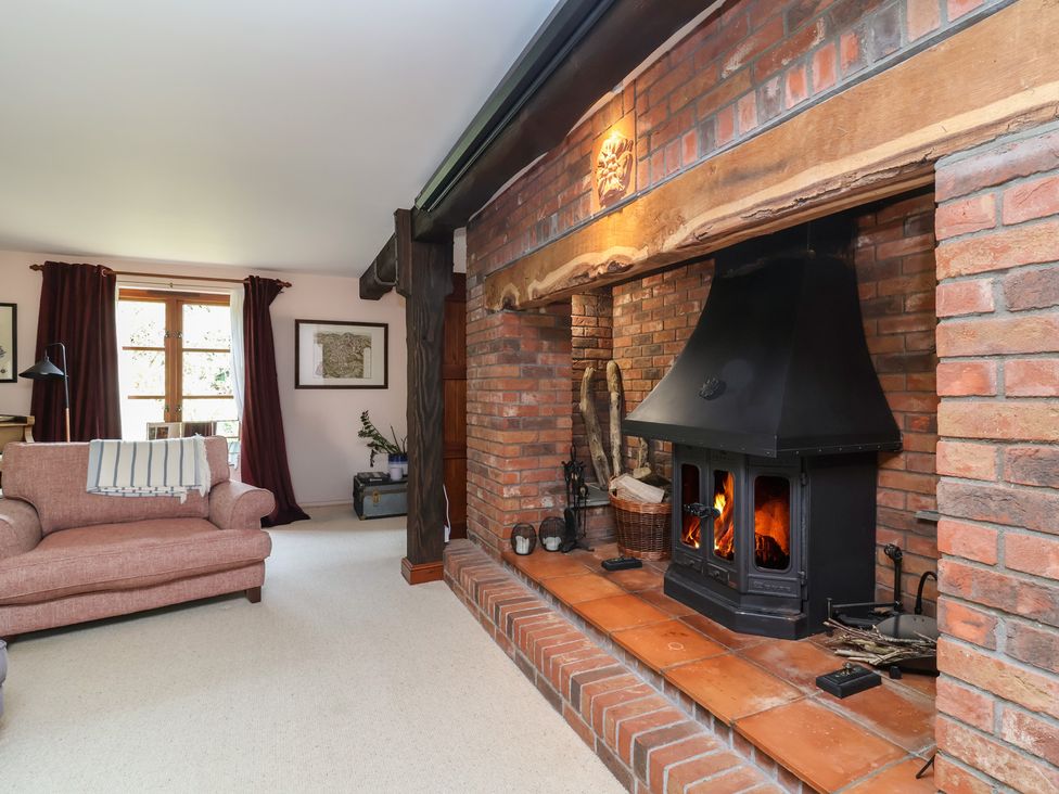 A living room with a fireplace and a sofa at Hedgerose in Goodleigh near Barnstaple