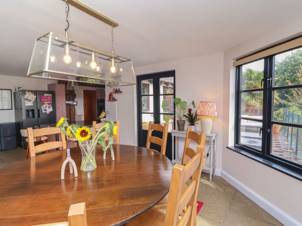A dining room with a wooden table and chairs at Hedgerose in Goodleigh near Barnstaple