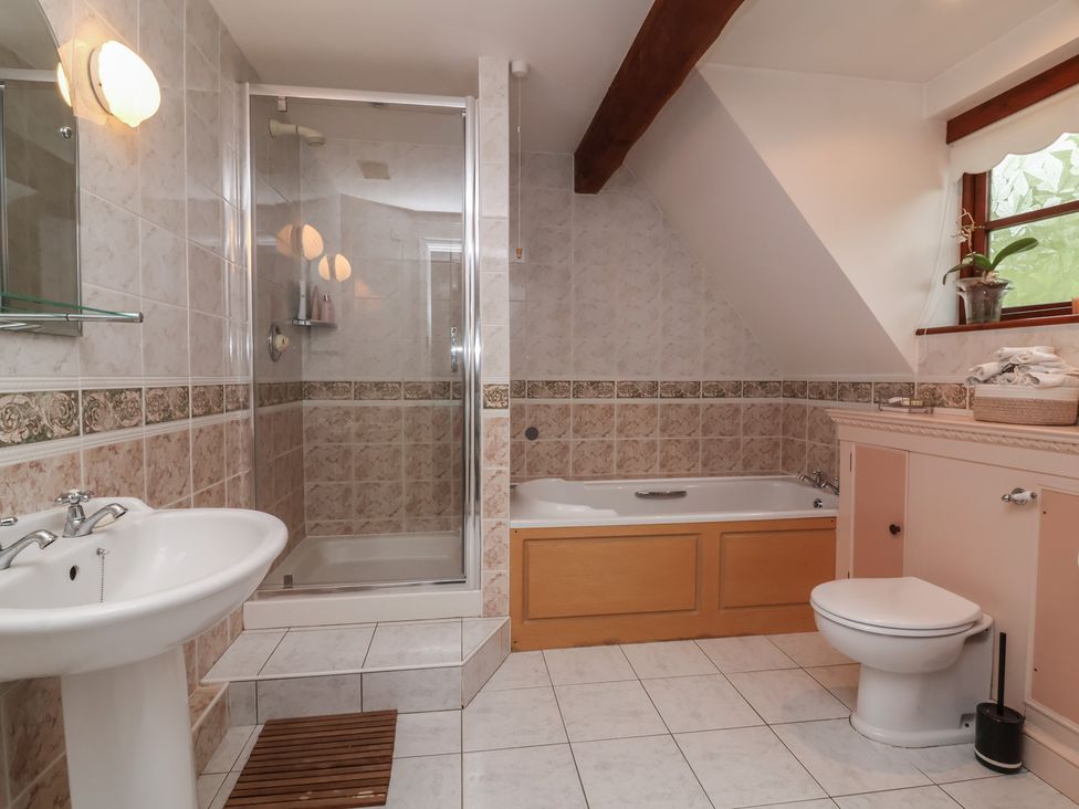 A bathroom with a shower, bathtub, sink, and toilet at Hedgerose in Goodleigh near Barnstaple