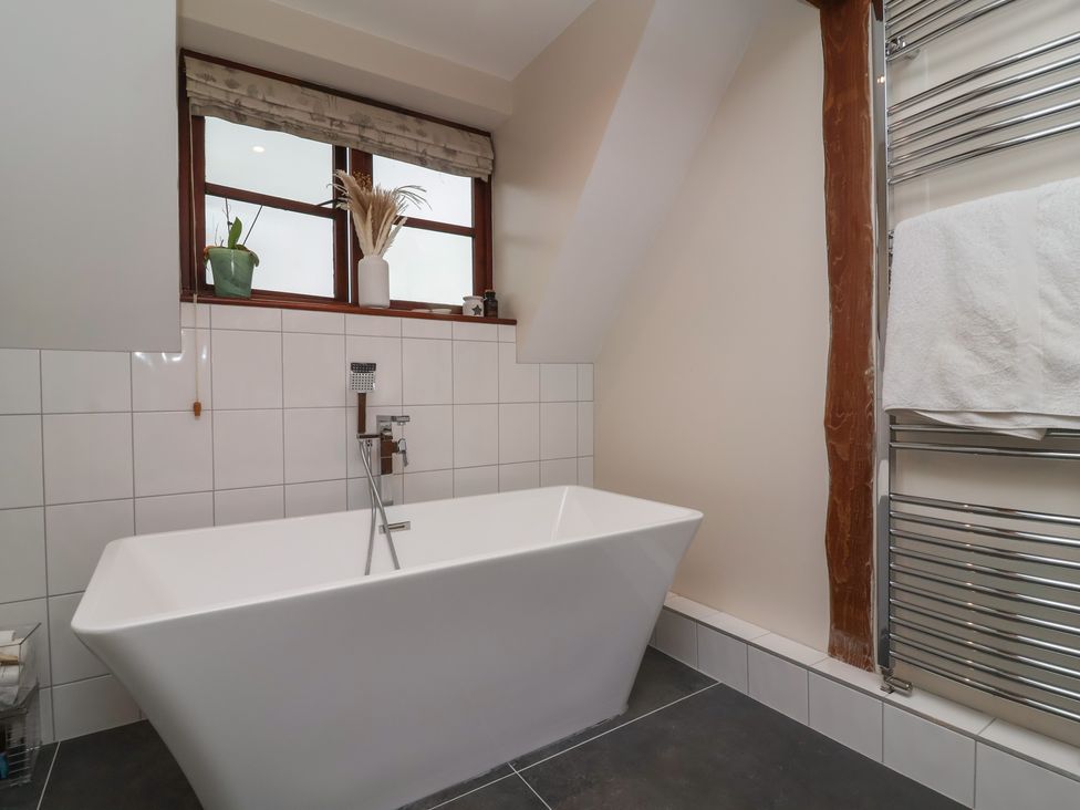 A bathroom featuring a bathtub and window at Hedgerose in Goodleigh near Barnstaple