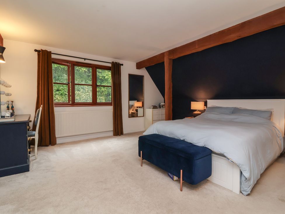A bedroom featuring a bed and large window at Hedgerose in Goodleigh near Barnstaple