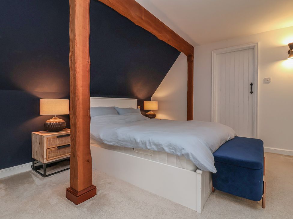 A bedroom featuring a bed with nightstands and lamps at Hedgerose in Goodleigh near Barnstaple