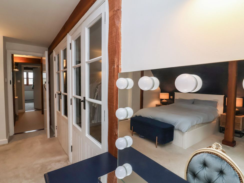 A bedroom with a bed and a mirror at Hedgerose in Goodleigh near Barnstaple