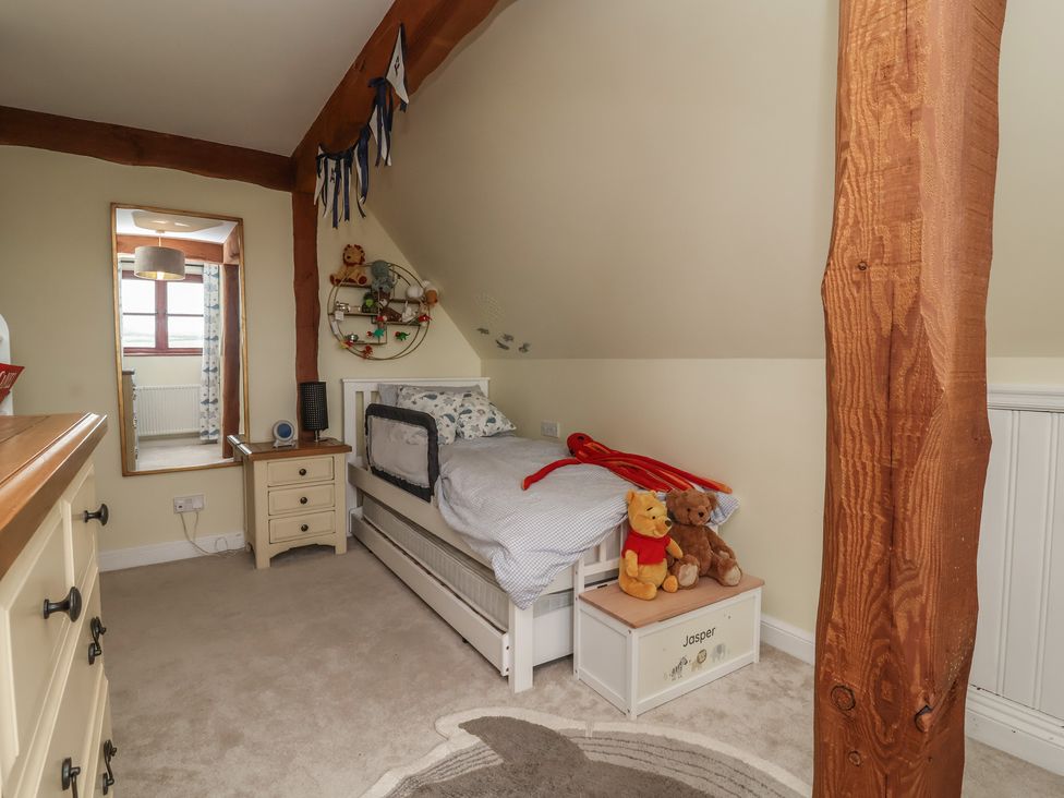 A bedroom with a bed, toys and a dresser at Hedgerose in Goodleigh near Barnstaple