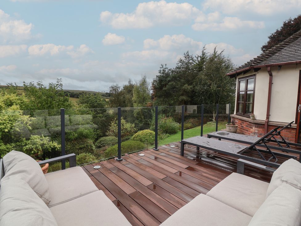 An outdoor area with a deck and glass railing at Hedgerose Goodleigh near Barnstaple