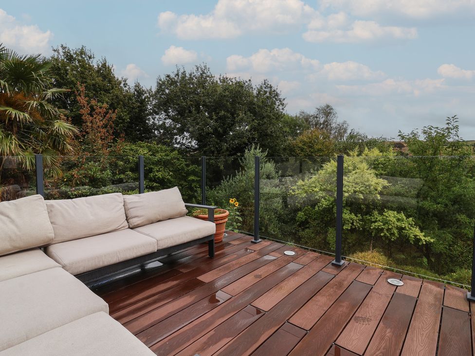 An outdoor seating area with a sofa and plants at Hedgerose in Goodleigh near Barnstaple
