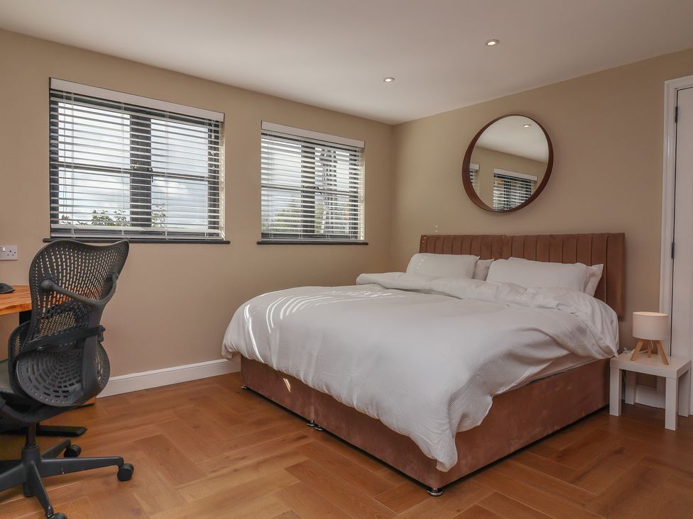 A bedroom with a bed, desk, and chair at Hedgerose in Goodleigh near Barnstaple