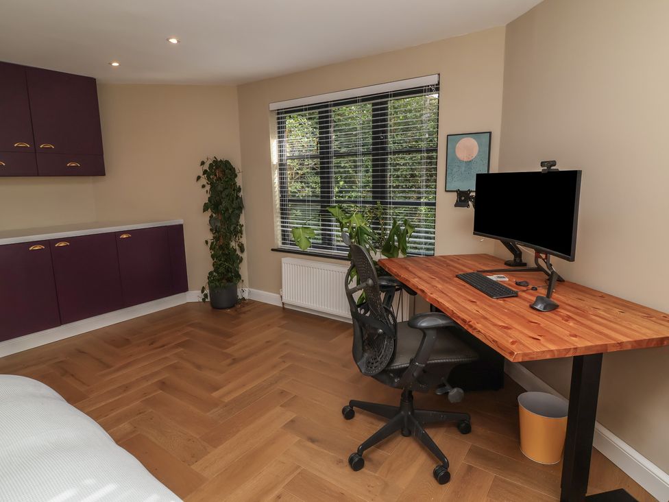 A home office with a desk and computer monitor at Hedgerose in Goodleigh near Barnstaple