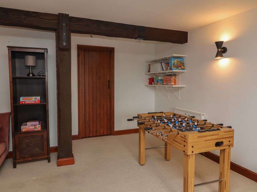 A games room with a foosball table and a bookshelf at Hedgerose Goodleigh near Barnstaple