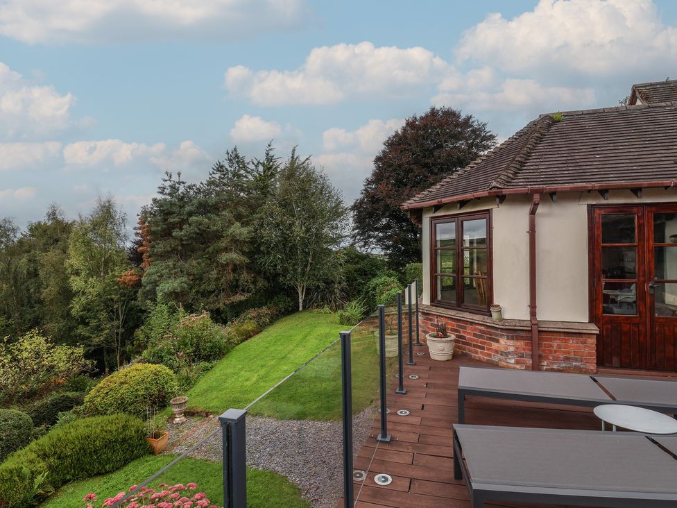 An outdoor area with decking, seating and garden at Hedgerose in Goodleigh near Barnstaple