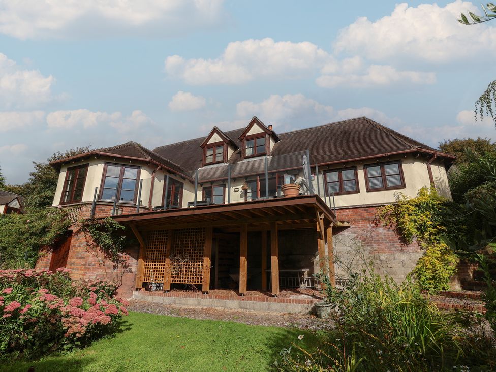 A house with a wooden deck and garden at Hedgerose in Goodleigh near Barnstaple