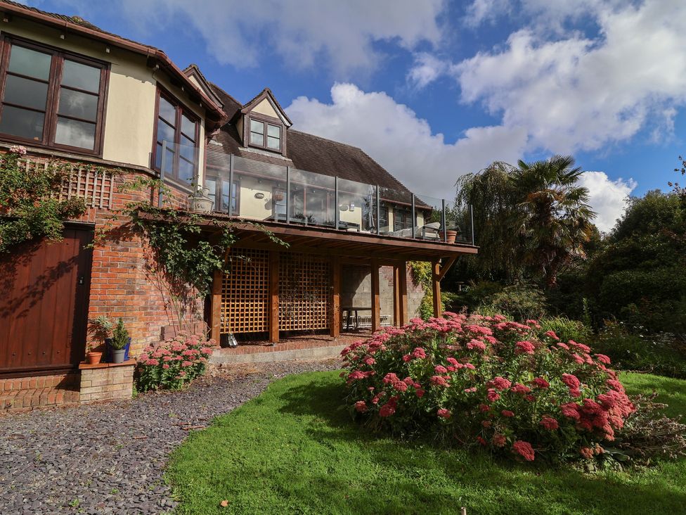A house with a balcony and flowers in the garden at Hedgerose in Goodleigh near Barnstaple