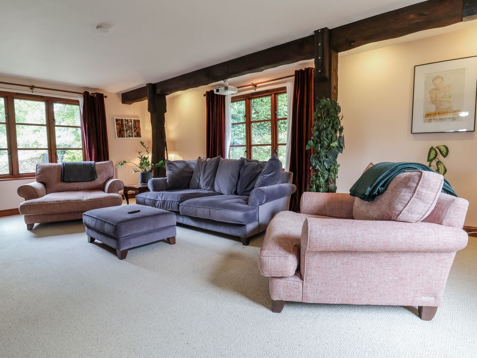 A living room with sofas and windows at Hedgerose in Goodleigh near Barnstaple