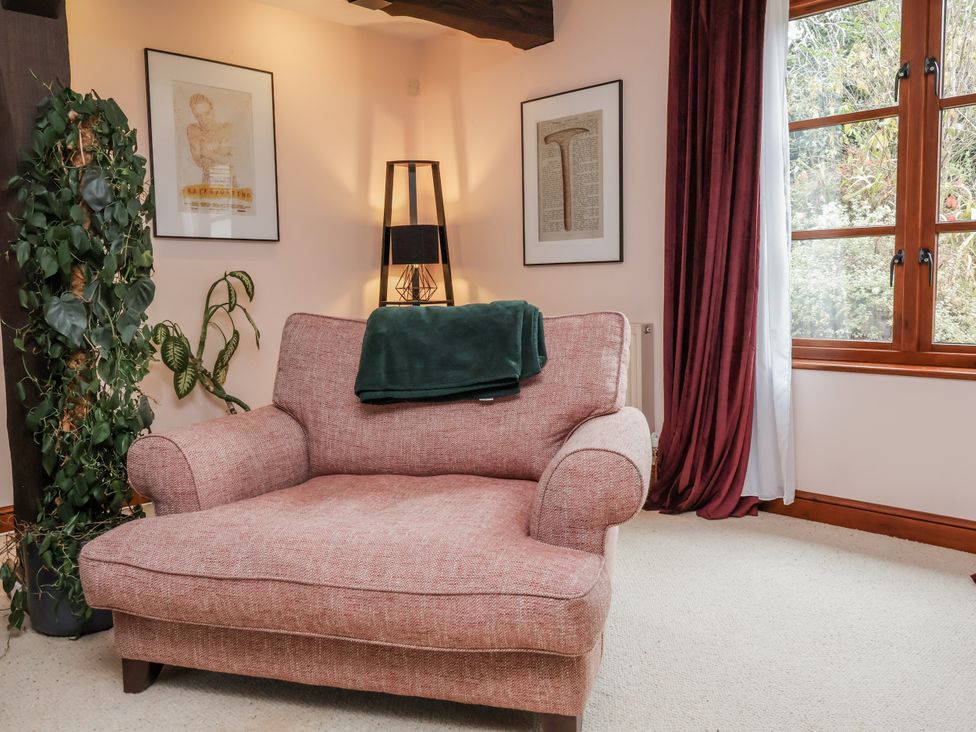 A living room with a pink chair and a lamp at Hedgerose near Barnstaple
