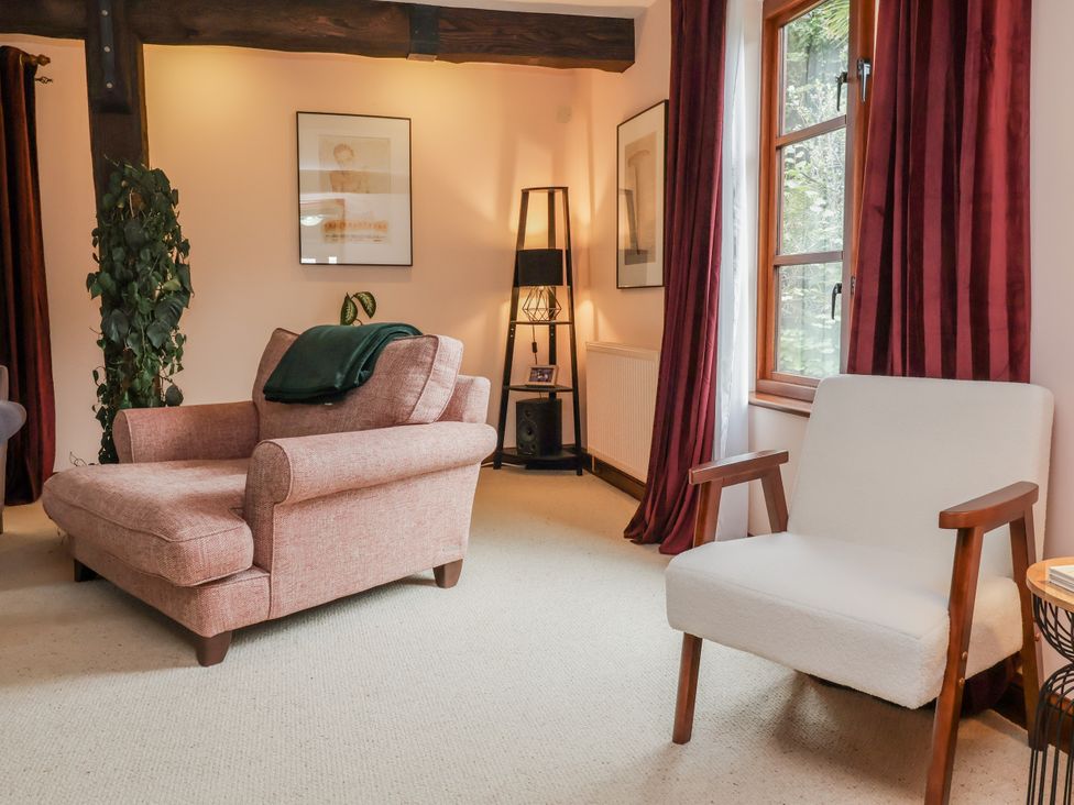 A living room with a sofa and armchair at Hedgerose in Goodleigh near Barnstaple