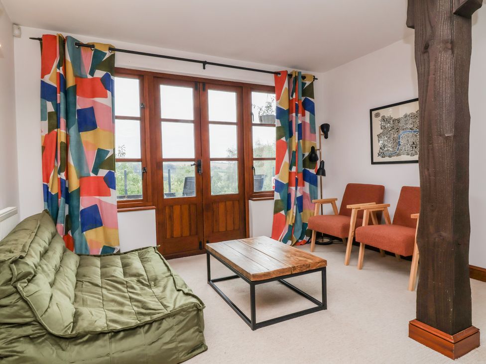 A living room with a sofa, coffee table, and armchairs at Hedgerose in Goodleigh near Barnstaple