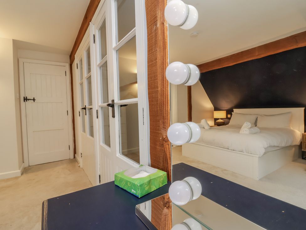 A bedroom with a bed and vanity mirror at Hedgerose in Goodleigh near Barnstaple