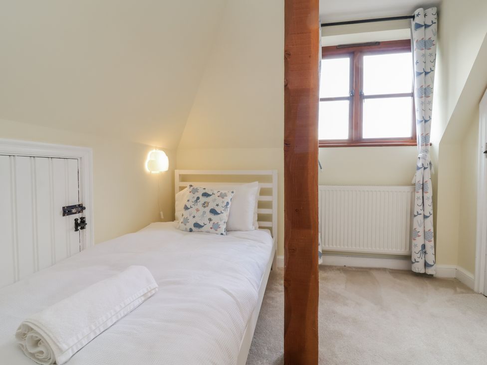 A bedroom with a bed and window at Hedgerose in Goodleigh near Barnstaple