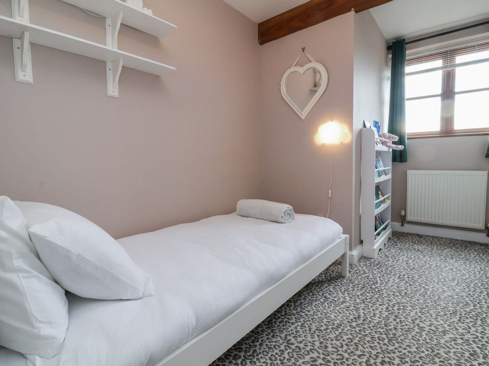 A bedroom with a bed and shelves at Hedgerose in Goodleigh near Barnstaple