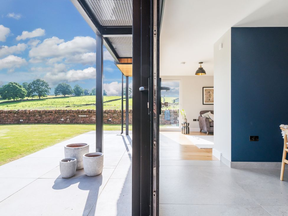 An indoor space with sliding doors leading to a garden view at a property