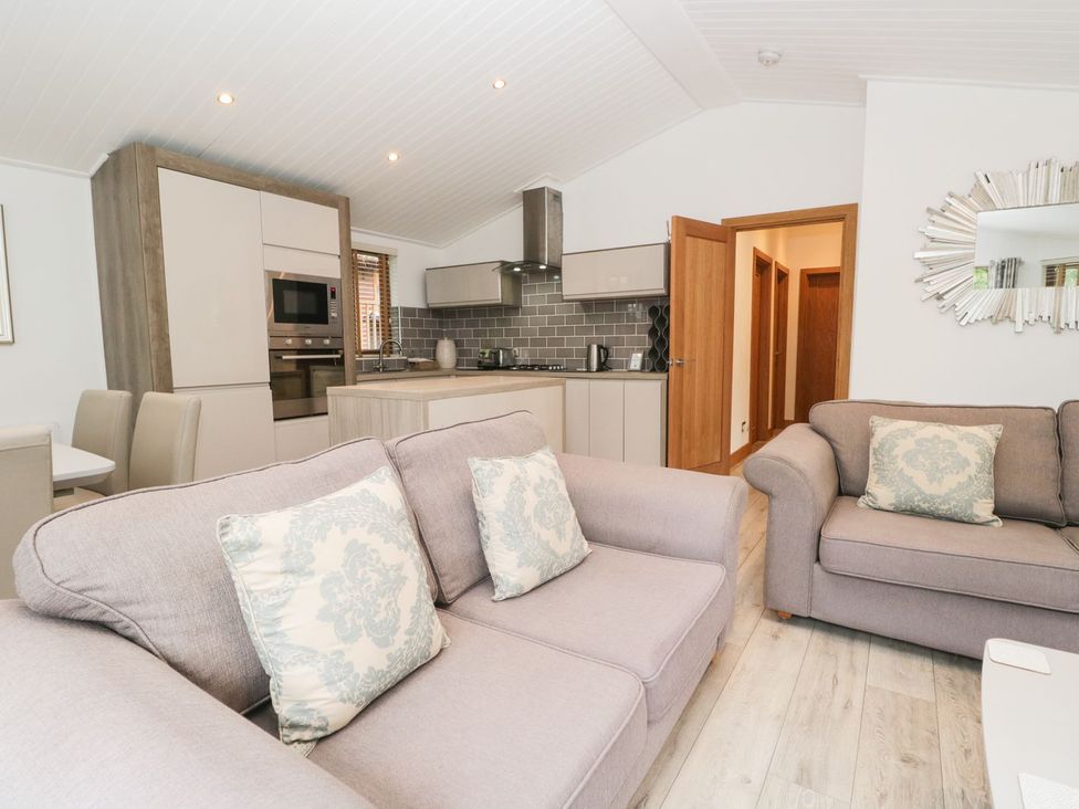 A living room with sofas and a dining area at Easedale Lodge, Waterside Wood 2, White Cross Bay near Windermere