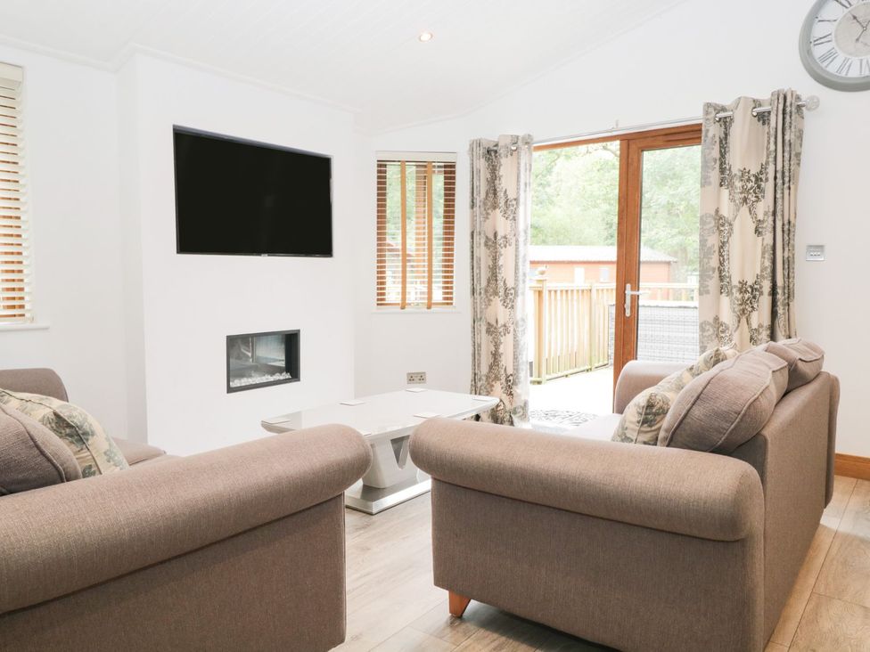 A living room with a television and sofa at Easedale Lodge Waterside Wood 2 White Cross Bay near Windermere
