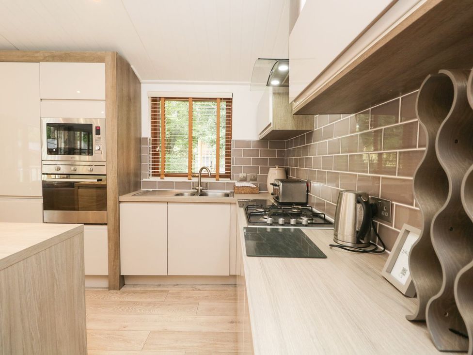 A kitchen with a sink and appliances at Easedale Lodge, Waterside Wood 2, White Cross Bay near Windermere