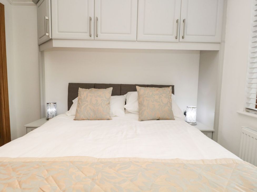 A bedroom with a bed and bedside tables at Easedale Lodge, Waterside Wood 2, White Cross Bay near Windermere