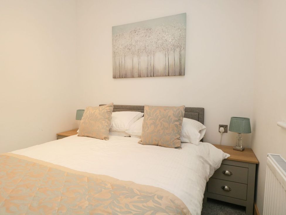 A bedroom with a bed and bedside table at Easedale Lodge, Waterside Wood 2, White Cross Bay near Windermere