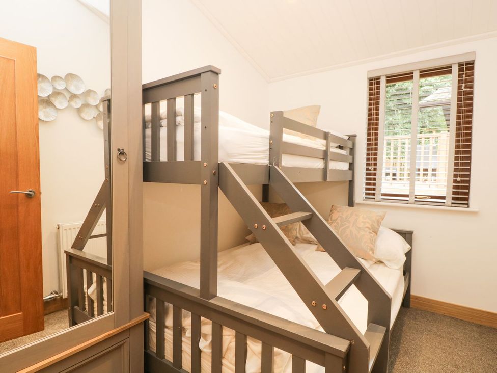 A bedroom with a bunk bed and a window at Easedale Lodge, Waterside Wood 2, White Cross Bay near Windermere
