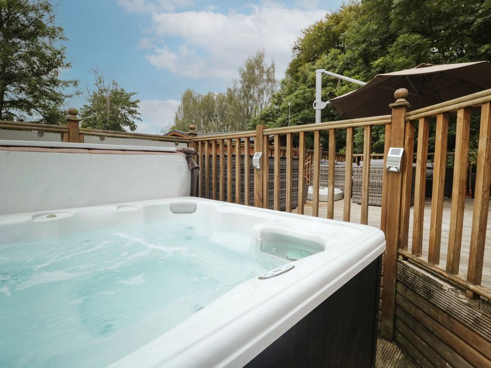 A hot tub next to a wooden fence at Easedale Lodge, Waterside Wood 2, White Cross Bay near Windermere