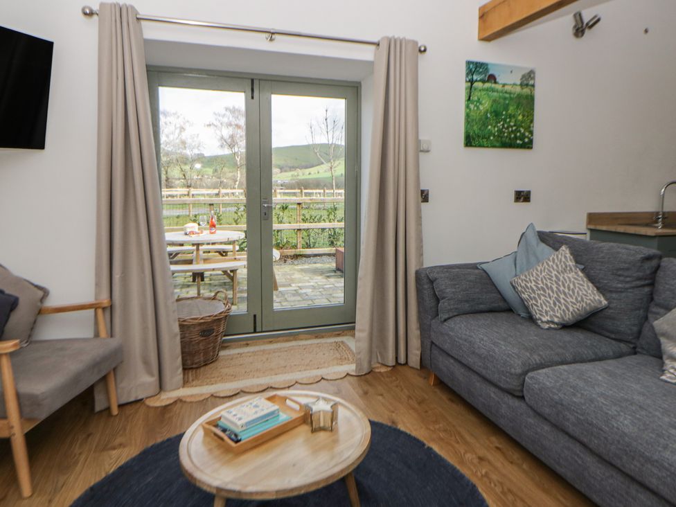 A living room with a sofa and coffee table at Eleri’s Barn in Nantmel near Rhayader
