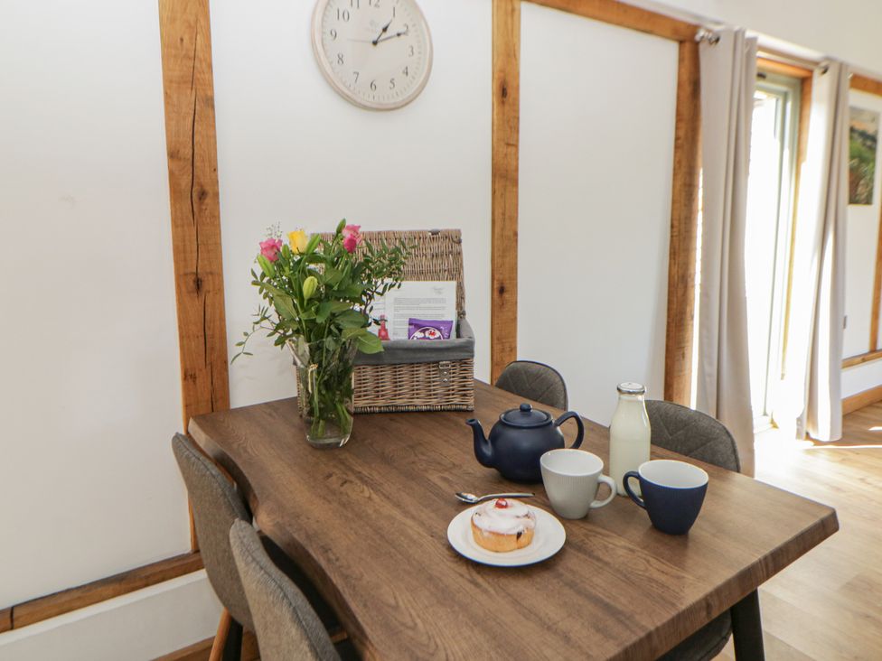 A dining room table set with a teapot, cups, milk bottle and cake at Eleri’s Barn Nantmel near Rhayader